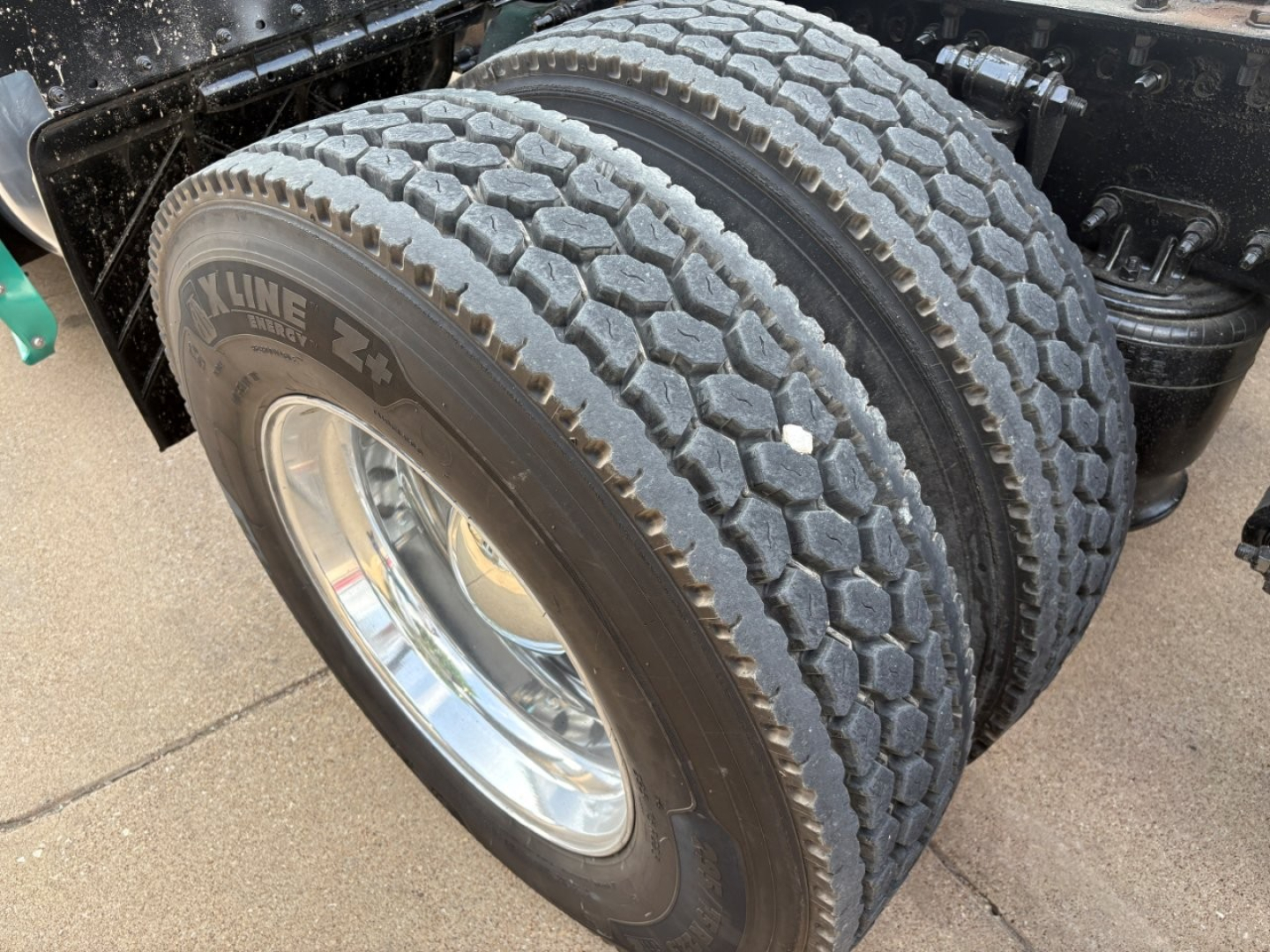 Dual rear tires of a Freightliner Cascadia 126 truck showing dual 22.5 inch tires with Kline branding on the tire sidewall and polished wheel rims.