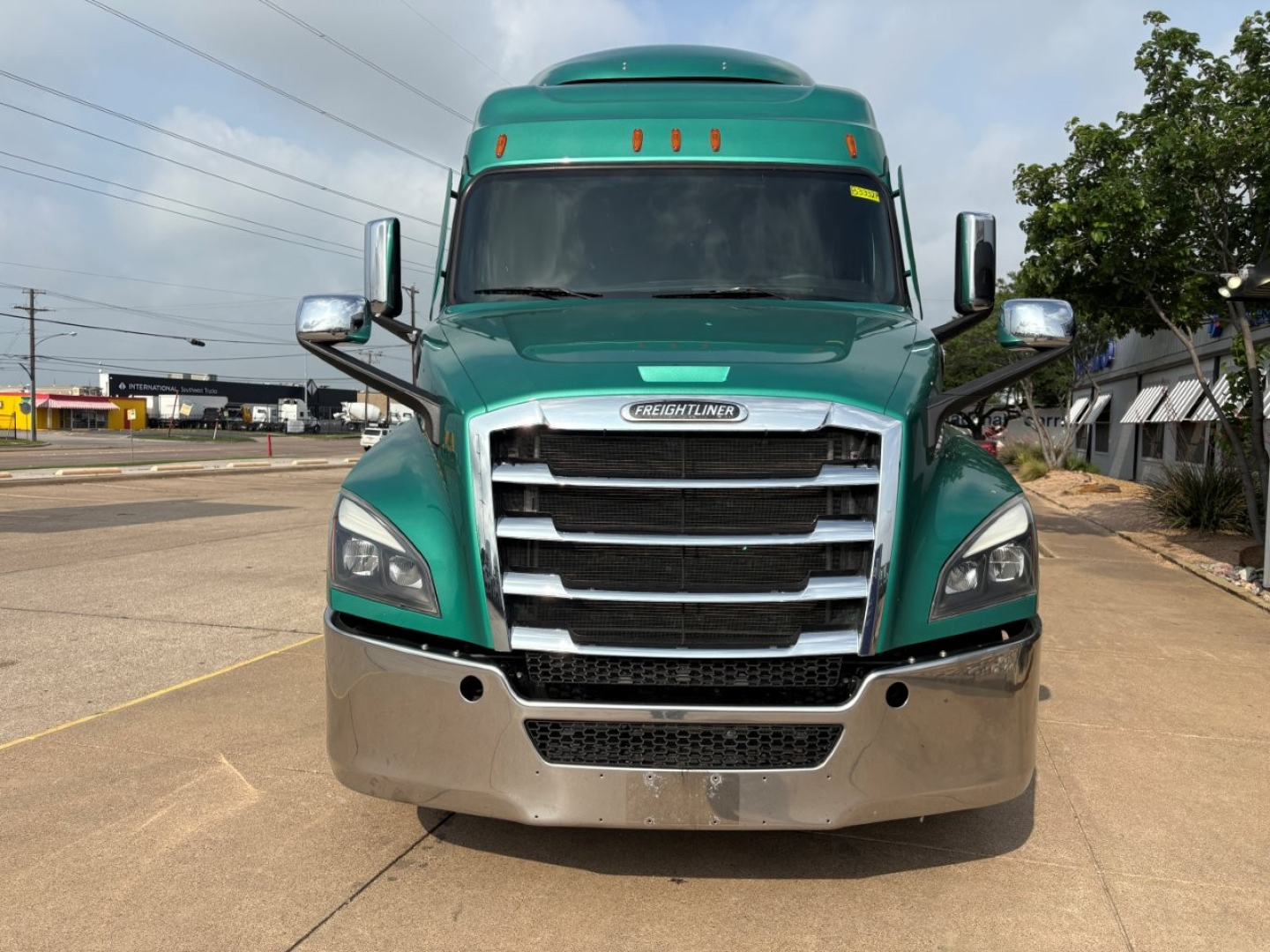 Freightliner Cascadia 126 truck front view showing chrome grille, green cab, and silver bumper.