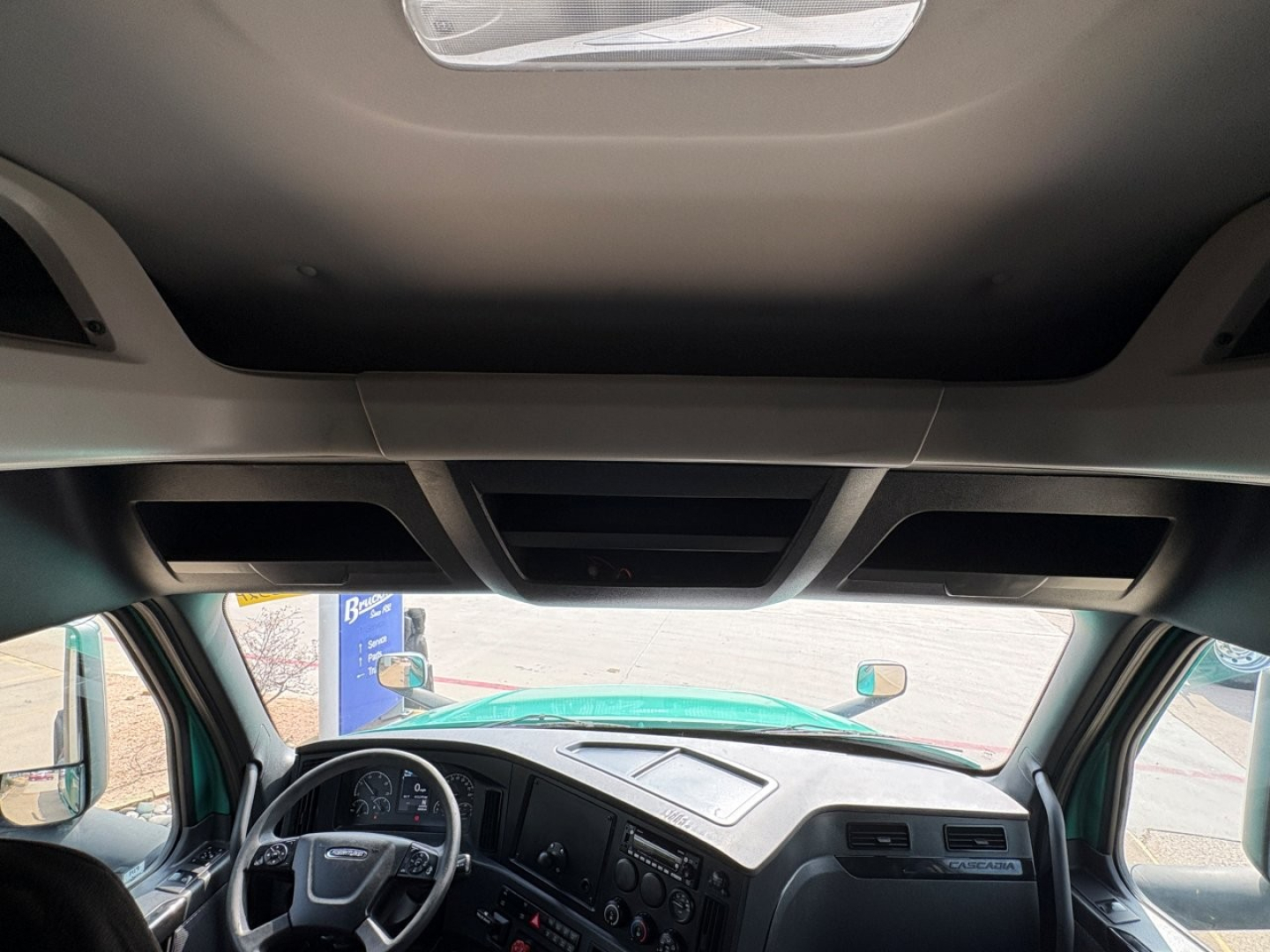 Truck interior ceiling view and dashboard of a 2023 Freightliner Cascadia 126 showing front cabin with overhead console.