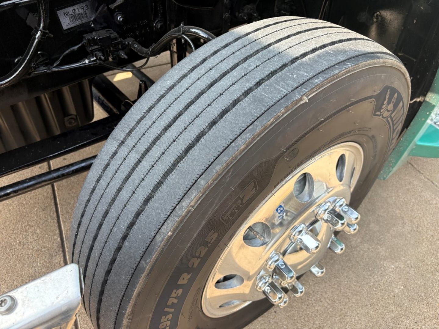 Rear wheel and dual front tires of a Freightliner Cascadia 126 tractor showing Goodyear or similar tires and wheel lugs.