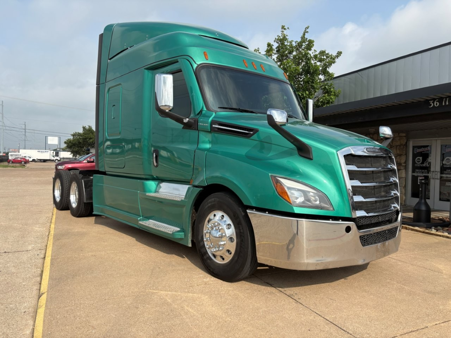 Truck cab: 2023 Freightliner Cascadia 126 in teal green, front three-quarter view, chrome front bumper, dual rear axles, sleeper cab, VIN 3AKJHHDV1PSNL0193 visible on listing