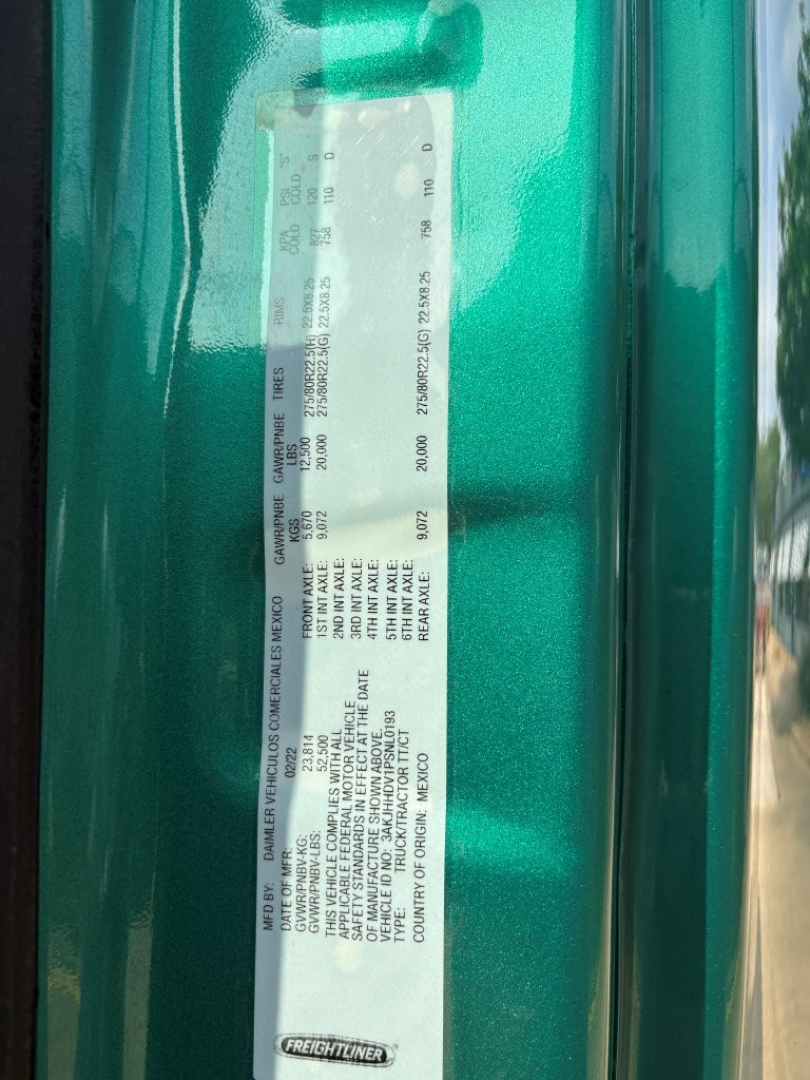 Label plate on Freightliner Cascadia 126 showing VIN and vehicle details. Text includes MAKE/FREIGHTLINER, VEHICLE TYPE, VIN 3AKJHHDV1PSNL0193, WEIGHT, AXLE RATINGS, MODEL, and other specs along a vertical sticker.