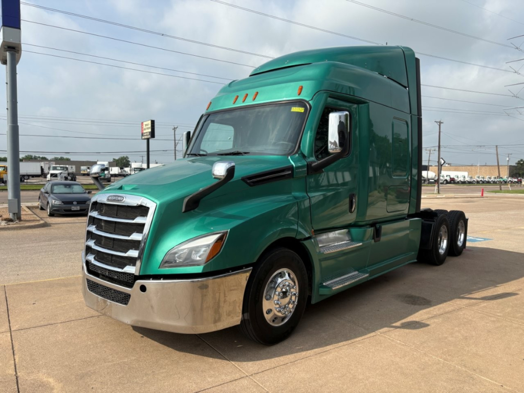 Green 2023 Freightliner Cascadia 126 tractor-trailer cab, side view, chrome front bumper, black grille, sleeper cab, no visible damage.