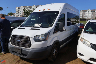 Ford Transit 2016 high-roof passenger van in white, front-left view, showing Ford grille and side mirrors.