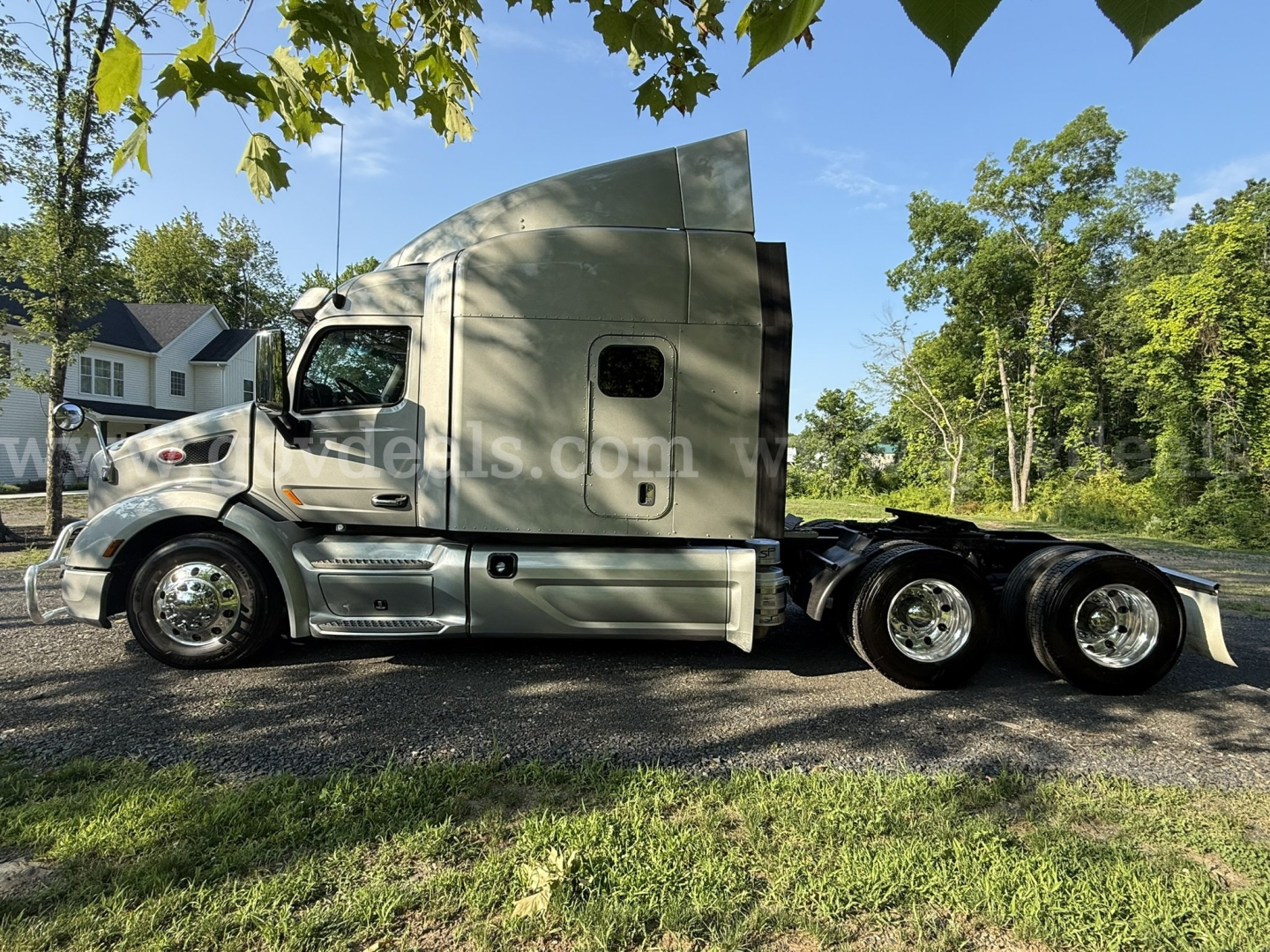 Side view of a 2019 Peterbilt 579 sleeper cab truck in service, showing the cab, fuel tanks, and dual rear axles with polished wheels.