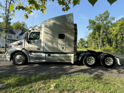 Side view of a 2019 Peterbilt 579 sleeper cab truck in service, showing the cab, fuel tanks, and dual rear axles with polished wheels.