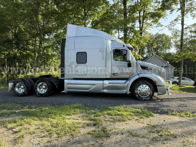 Truck side profile of a 2019 Peterbilt 579 with sleeper cab, chrome wheels, body panels, and dual rear axle on a gravel surface.