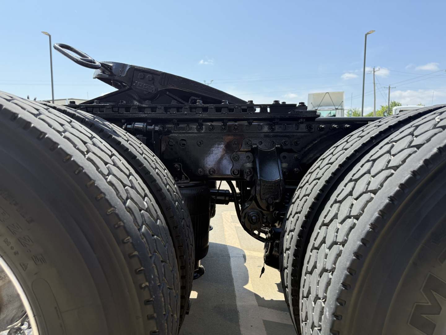 Mack AN64T truck chassis showing dual rear axles and drivetrain components between the tires, with visible frame and linkage.