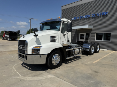 White 2021 Mack AN64T conventional daycab truck shown in parking lot near a used truck center, with 6-wheel configuration and chrome bumper.