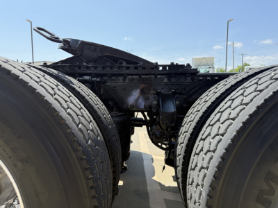 Mack AN64T truck chassis showing dual rear axles and drivetrain components between the tires, with visible frame and linkage.