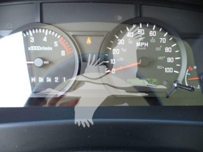 Dashboard view of a 2024 Isuzu NPR-HD showing gauge cluster with tachometer, speedometer, and warning indicators.