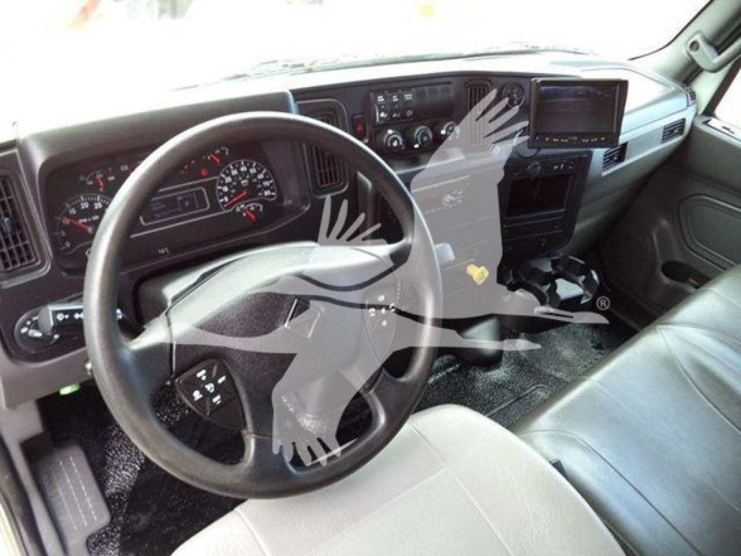 Cab interior of a 2020 International MV showing steering wheel, dashboard, and gear area with center display.