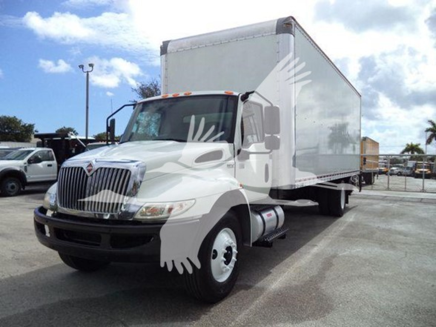 Truck in a lot showing a 2020 International MV box truck with white cab and box, front grille, side mirrors, and cargo box.