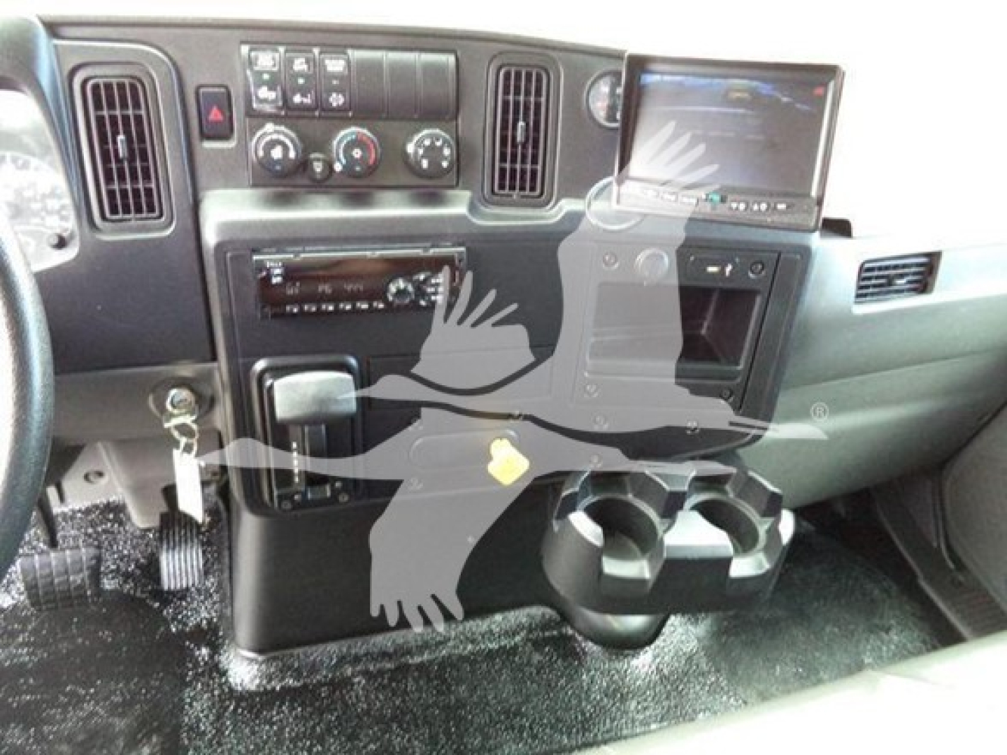 Cabin interior of a 2020 International MV truck showing dashboard controls, center console, cup holders, and a mounted screen.