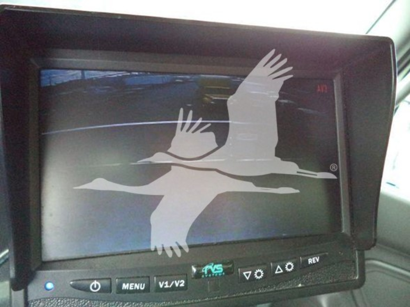 In-vehicle monitor displaying a logo of a bird in flight overlaying a landscape, with control buttons below the screen.
