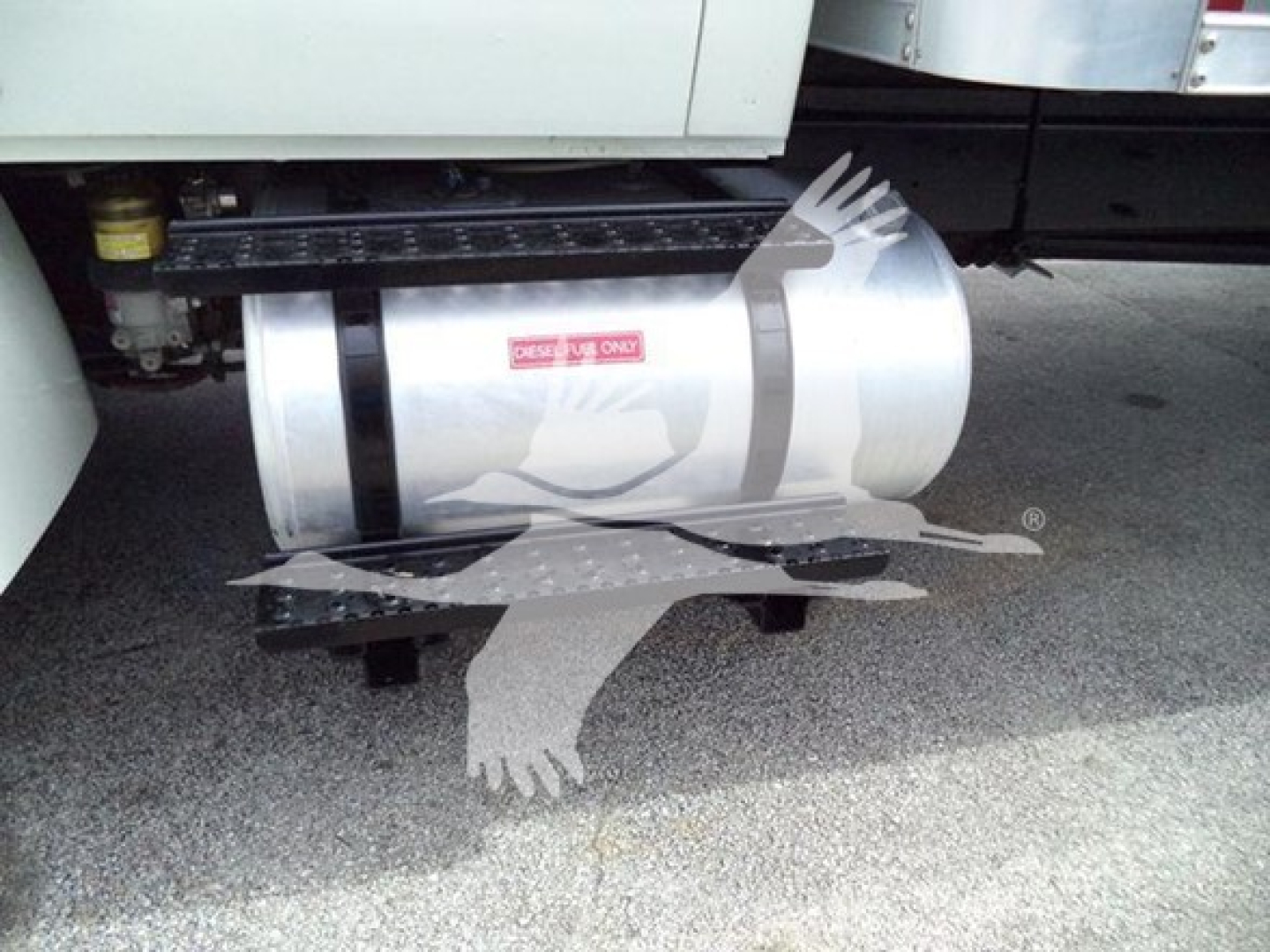 Truck side view showing fuel tank undercab and steps with a sticker; no legible model text visible.