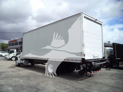 Box truck rear and side view showing a large white cargo box with a hydraulic lift undercarriage and rear doors; no legible text visible.