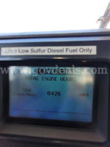 Gauge/monitor showing Total Engine Hours 8426 HRS with label Ultra Low Sulfur Diesel Fuel Only visible above. 