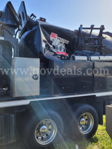 Vacuum truck side view with Mack GU713 chassis and dual rear wheels, Vac-Con logo on tank, diamond plate toolbox, hydraulic components visible.