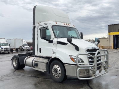 Freightliner Cascadia 116 daycab tractor in a dealership lot, white cab with grille guard and high sleeper