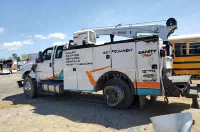 Ford F750 service body truck with crane, side text reading READY EQUIPMENT, SAFETY, heavy hauling, and various service labels.