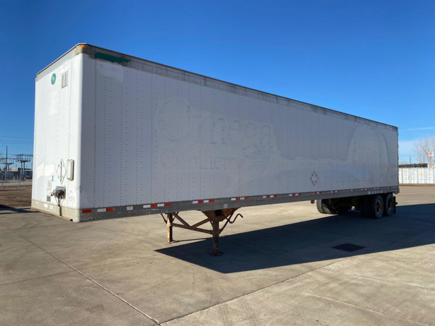 Great Dane semi-trailer in a lot showing side and rear, white with faint logos, landing gear and wheels visible.