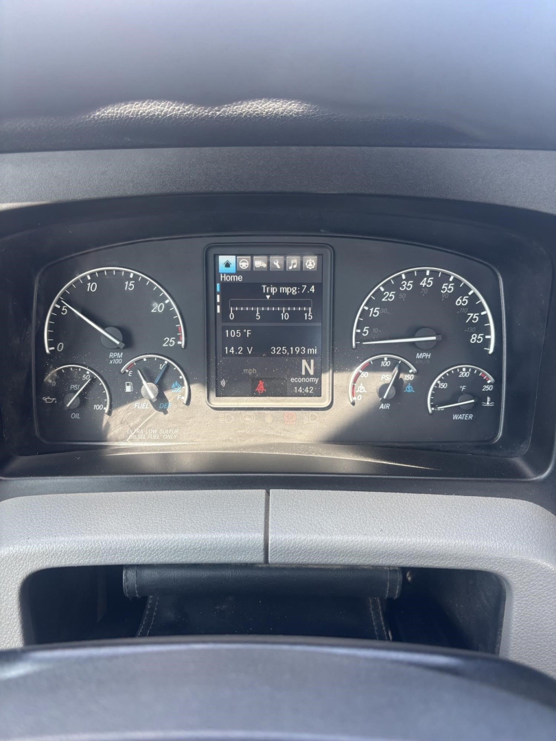 Dashboard of a Freightliner Cascadia 126 showing instrument cluster and center display with trip data.