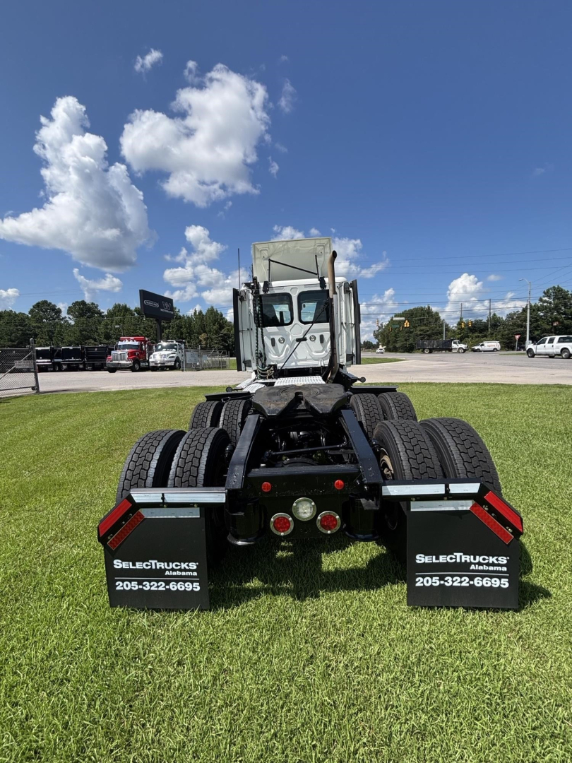 Rear view of a 2021 Freightliner Cascadia 126 truck chassis showing dual rear axles, black mud flaps with SelectTrucks branding, and tail lights.