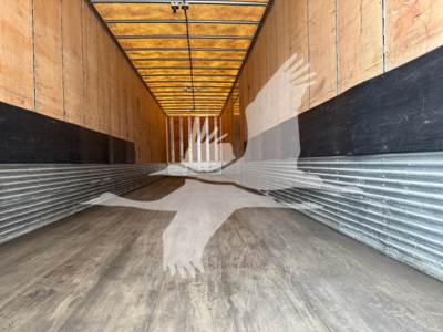 Great Dane swing door trailer interior showing wood walls, metal floor, side door, and lighting along the ceiling.