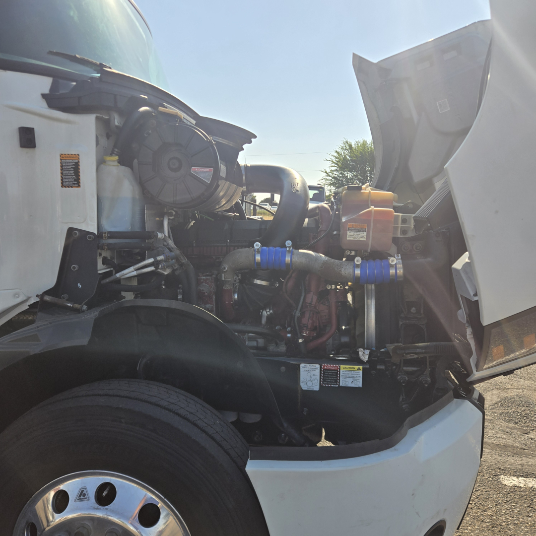 Truck engine bay of a 2020 Mack Anthem, view of the front left side with open hood exposing turbocharger, hoses, and engine components.