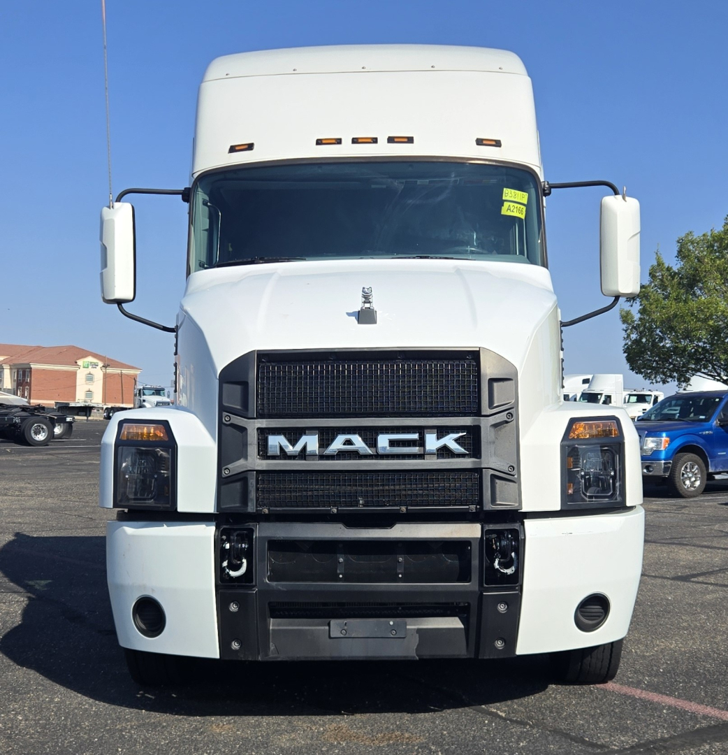 Mack Anthem truck front view showing large grille, headlights, and bumper. White exterior, cab-over style with mirrors on both sides and windshield.