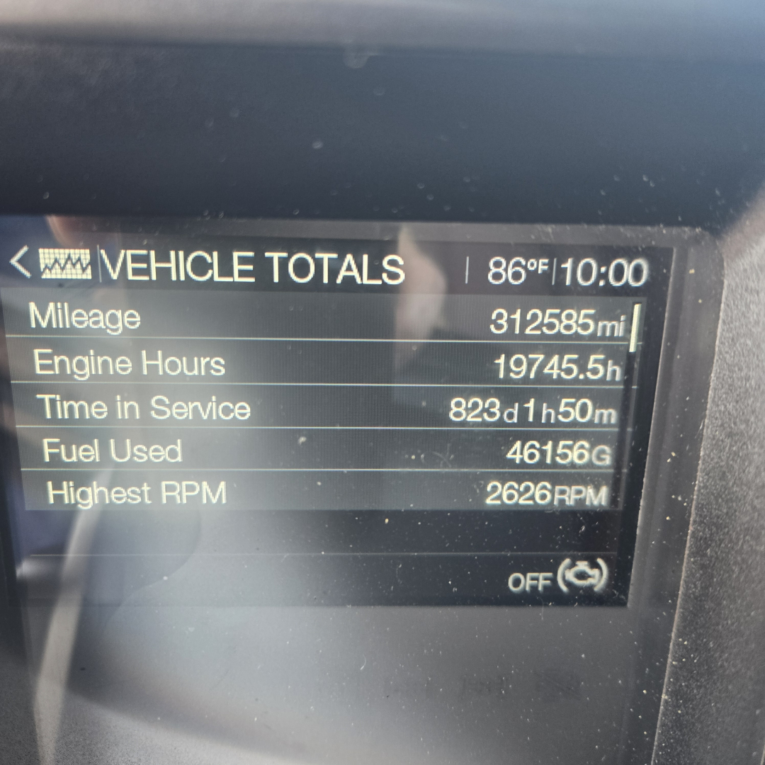 Vehicle totals screen in a Mack Anthem showing mileage 312585 mi, engine hours 19745.5 h, time in service 823d 1h 50m, fuel used 46156 gal, highest RPM 2626 RPM.