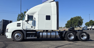 Truck side view of a white 2020 Mack Anthem sleeper cab with fuel tanks and rear axle configuration visible.
