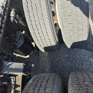 Truck axle view with dual rear tires and suspension components visible.