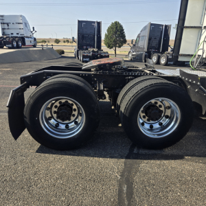 Tractor trailer chassis showing dual rear axles with polished steel wheels.
