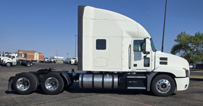 Truck side view of a 2020 Mack Anthem sleeper cab showing the white tractor with three rear axles and fuel tanks