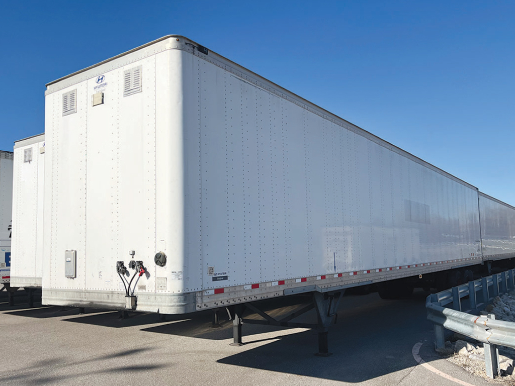 Trailer showing a white Hyundai aluminum dry van trailer with landing gear, front corner details, and support legs.