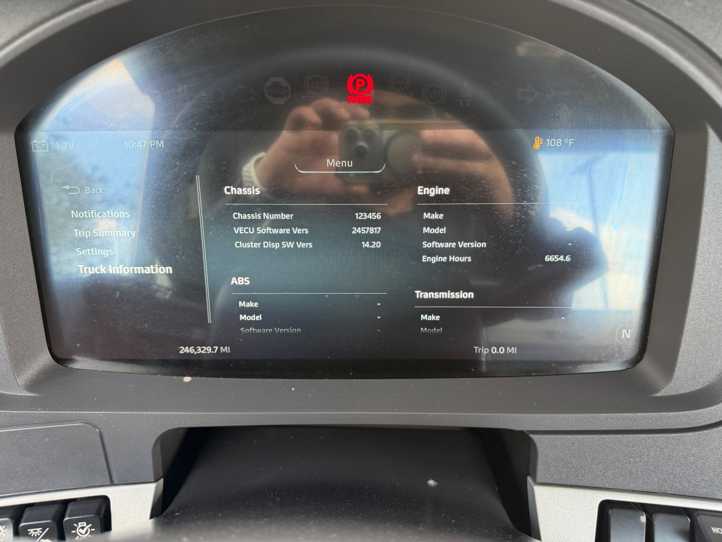 Kenworth T880 dash display showing chassis and engine info on the digital gauge cluster in a daycab truck cab.