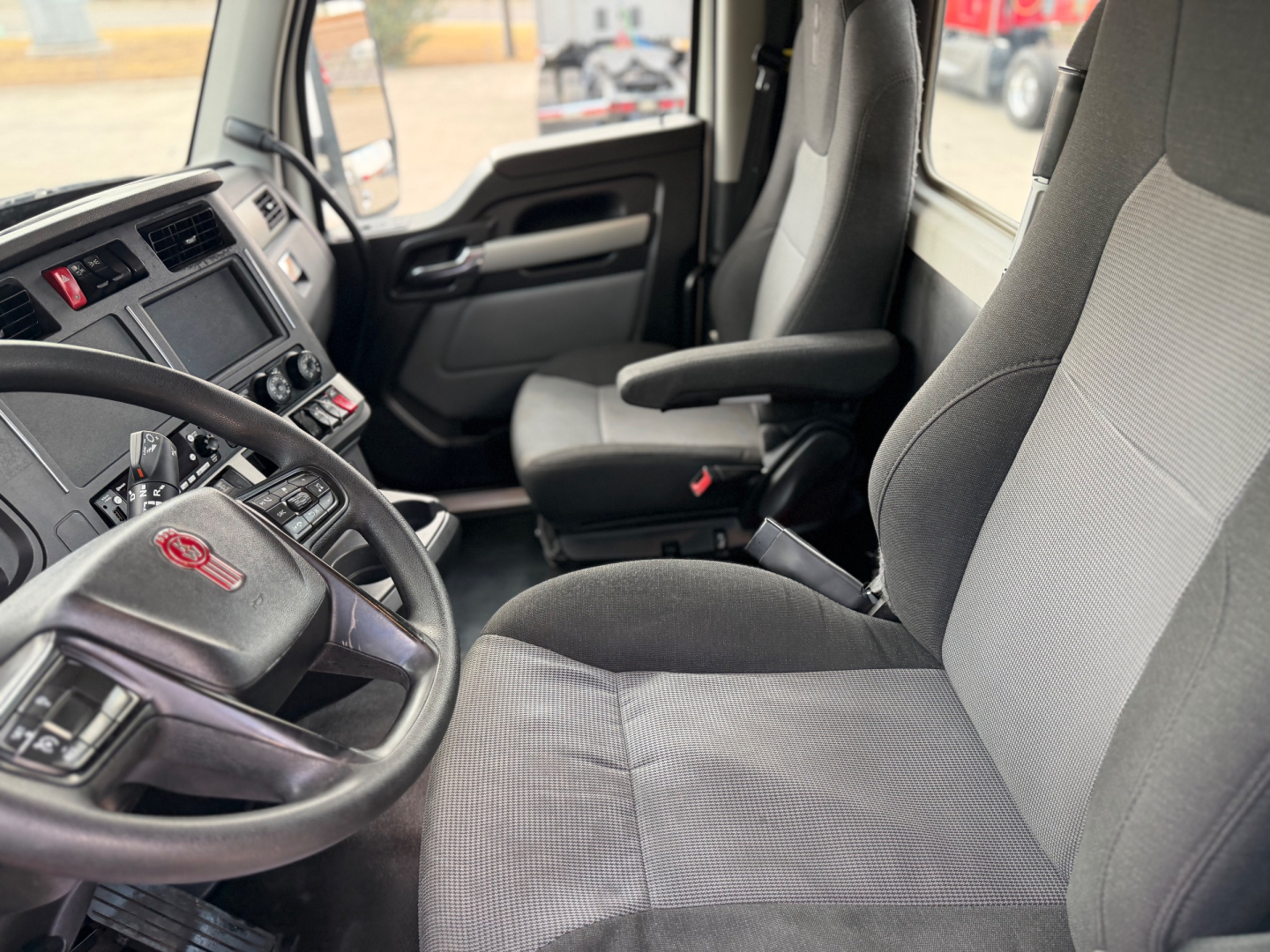 Kenworth T880 truck interior showing front seats and steering wheel with Kenworth logo.