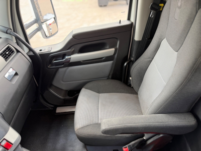 Kenworth T880 cab interior showing front passenger seat and door panel with armrest and window controls.