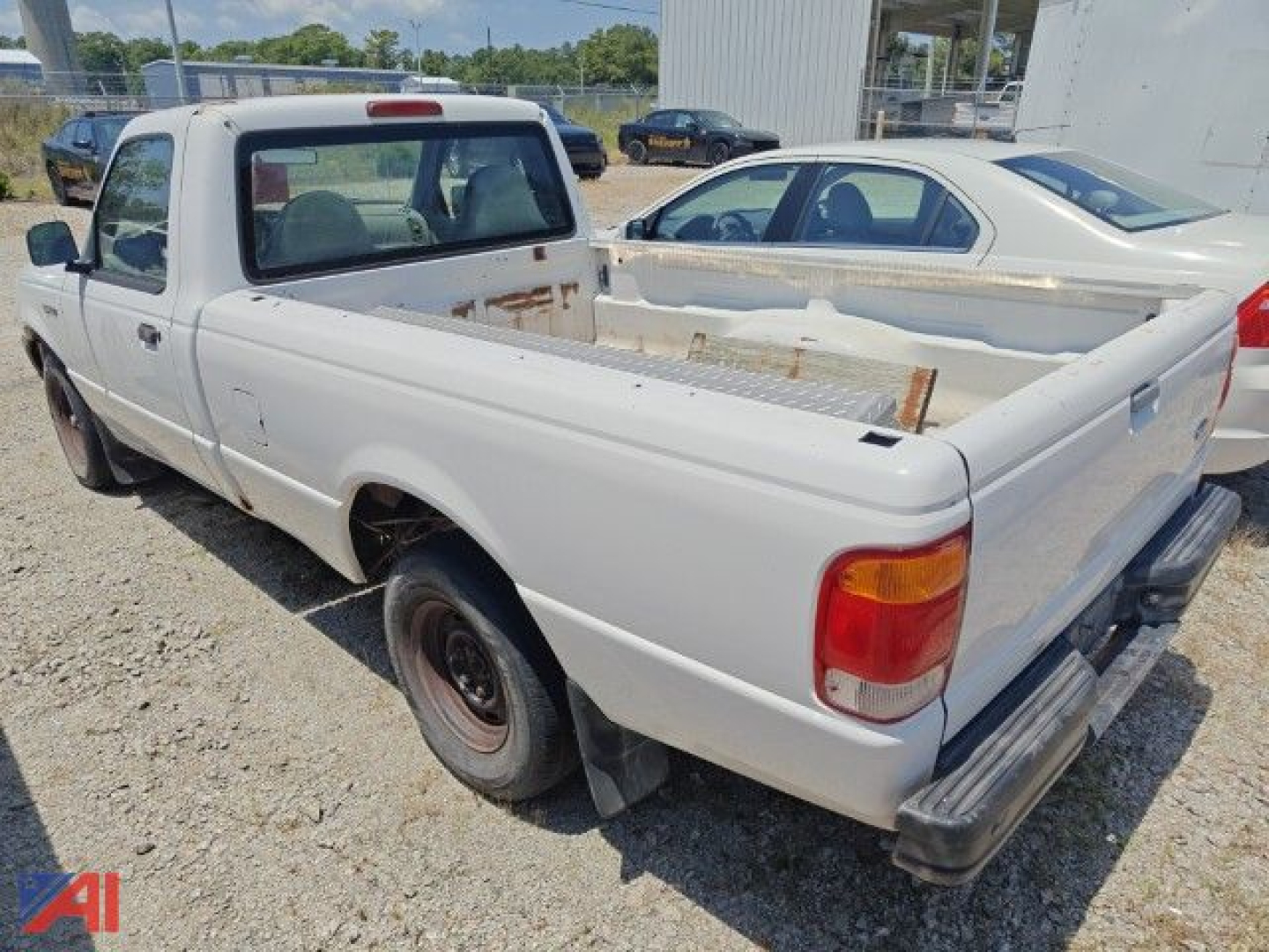 1999 Ford Ranger pickup truck in white, rear/side view showing rust-free-looking bed with metal utility rack and single cab, 2wd