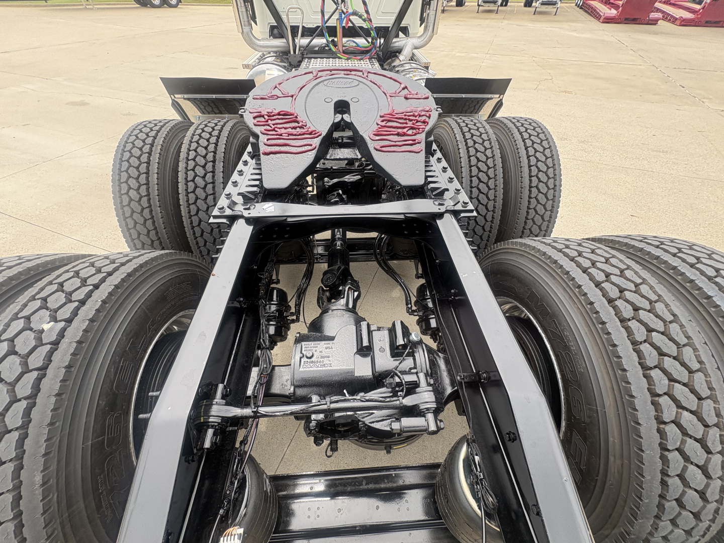 Mack PI64T truck chassis view showing rear axles, differential, suspension components, and fifth-wheel plate mount.