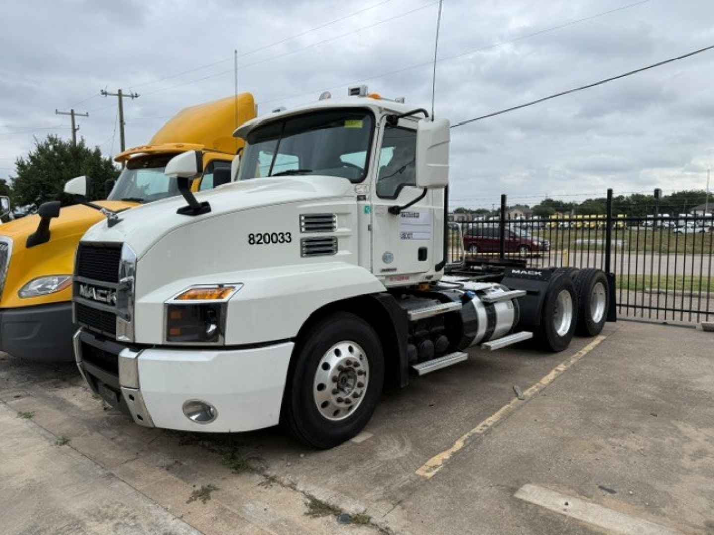 Truck cab showing 2020 Mack Anthem daycab with white exterior and registration numbers on door. Side chassis visible with fuel tanks and steps.