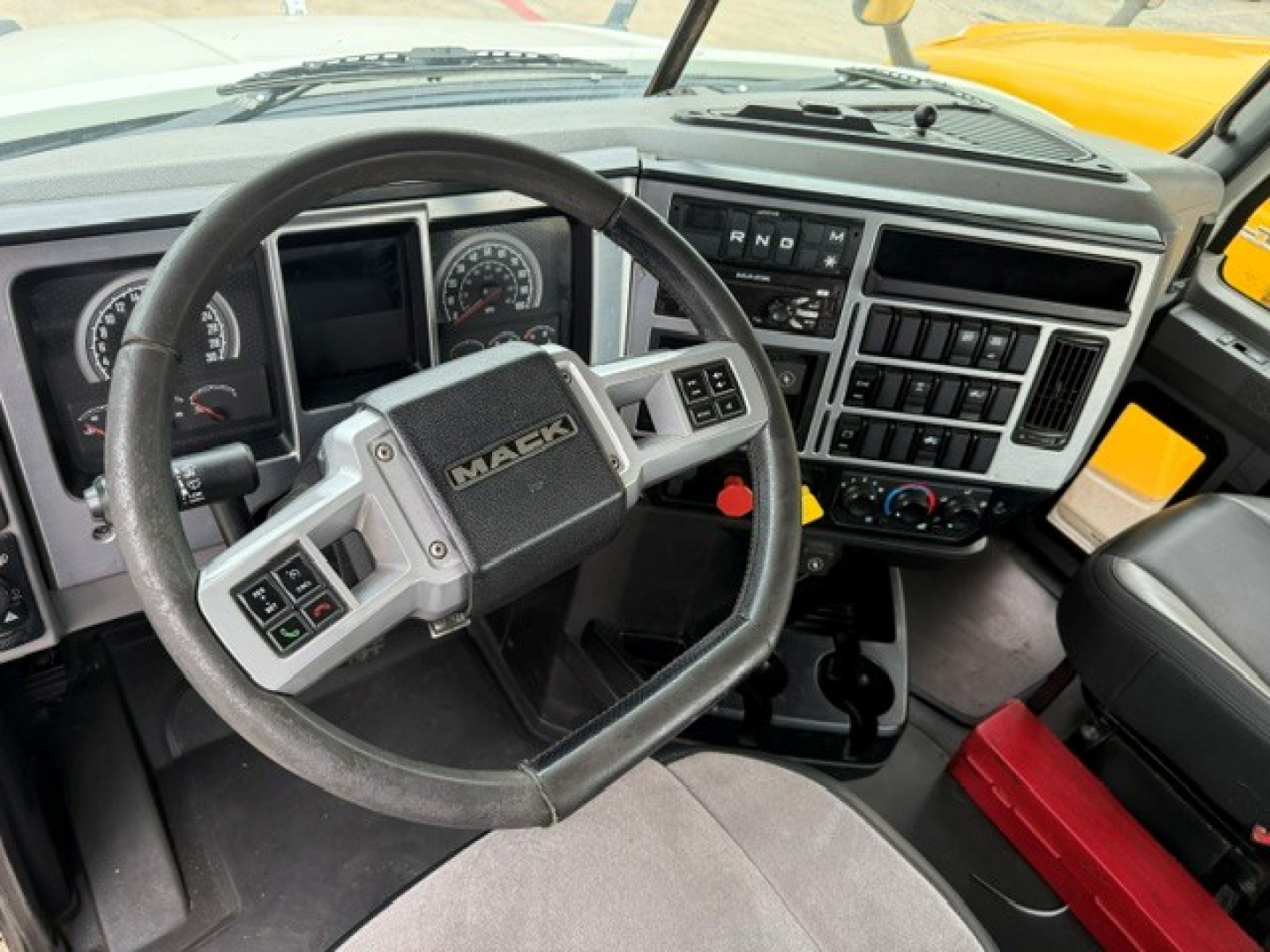 Truck steering wheel and dashboard of a 2020 Mack Anthem conventional daycab showing the steering wheel with Mack logo, instrument cluster, center controls, and dashboard layout.