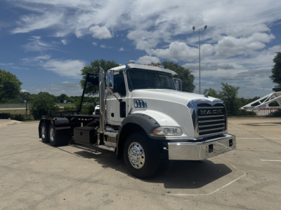 Mack GR64B truck chassis with white cab, chrome bumper, and heavy-duty wheel set. No visible labels readable beyond exterior features.