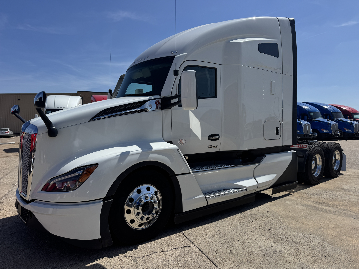 Kenworth T680 tractor-trailer side view showing aerodynamic white cab and sleeper, chrome wheels, and fuel tanks.