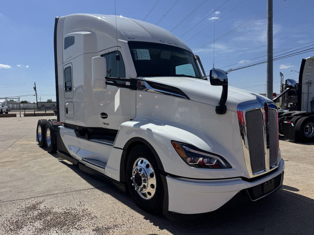 Kenworth T680 tractor with sleeper cab, front grille, headlights visible and a sticker on the windshield.
