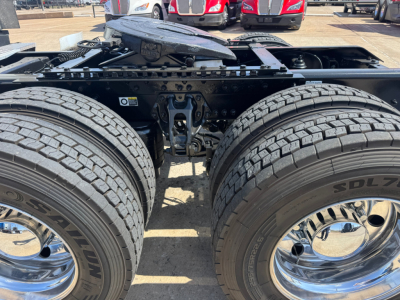 Kenworth T680 truck chassis rear view showing dual tandem wheels and suspension components with chrome wheels.