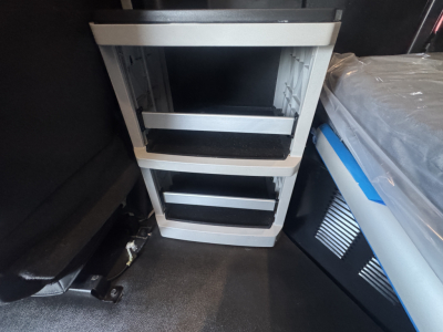 Kenworth T680 interior module with metal racks and empty shelves in a storage area.