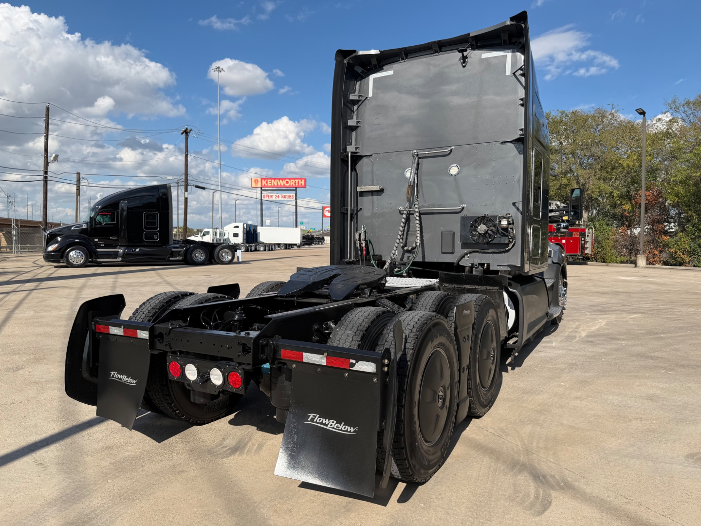 Kenworth T680 truck tractor rear and cab mirror view showing fifth wheel and dual rear axles with mud flaps